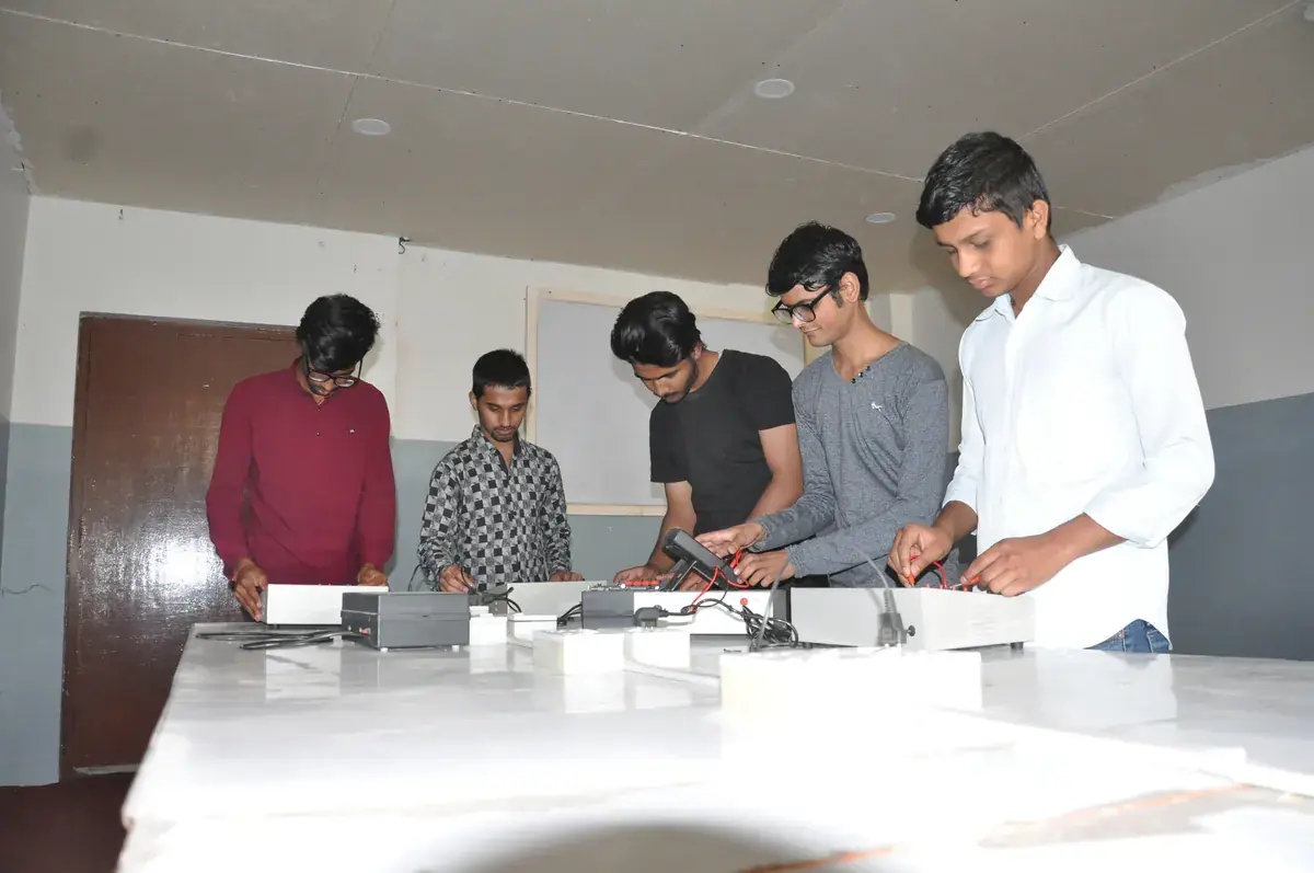 Six students at a laboratory bench taking readings from instrument boxes with a handheld meter