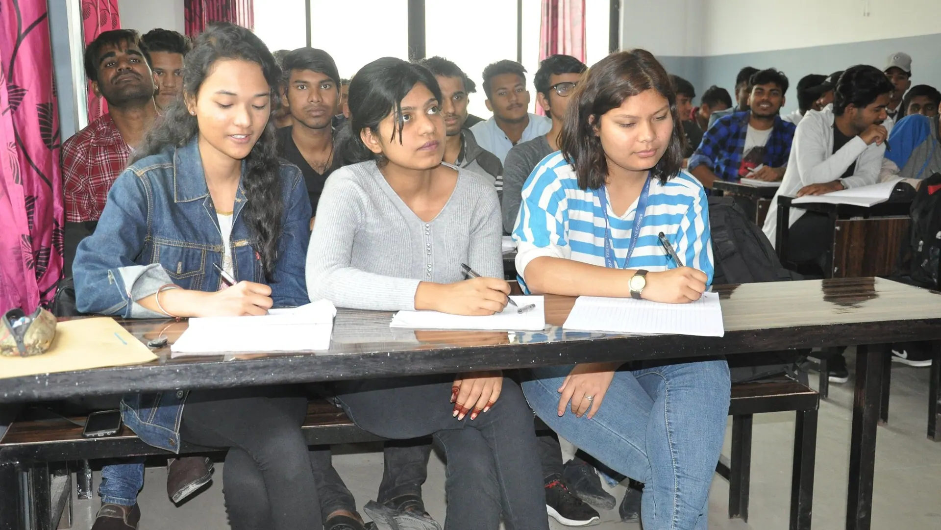 ICE students taking notes at the classroom benches during a lesson
