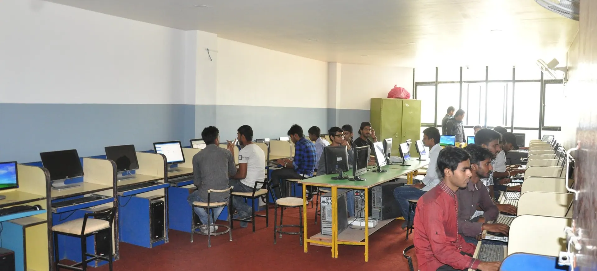 Students working at desktop machines down both sides of the computer laboratory