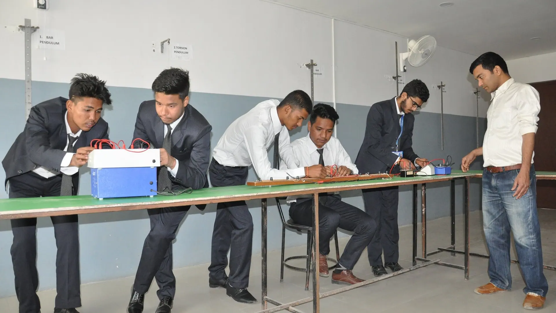Electronics engineering students taking readings along the laboratory instrumentation bench