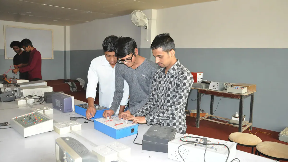 Three ICE students setting up a circuit trainer together on the laboratory bench