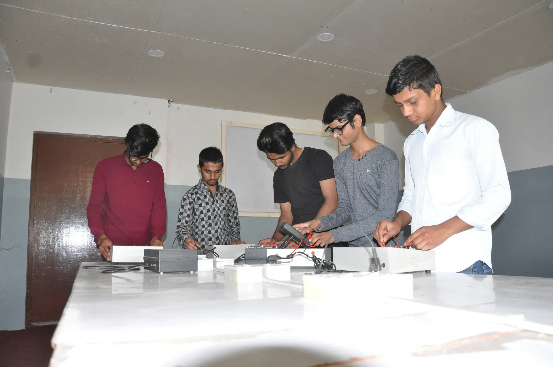 Electronics engineering students testing training circuits together