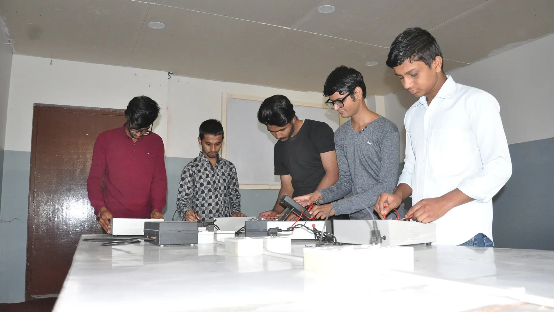 Students testing an electronics project together