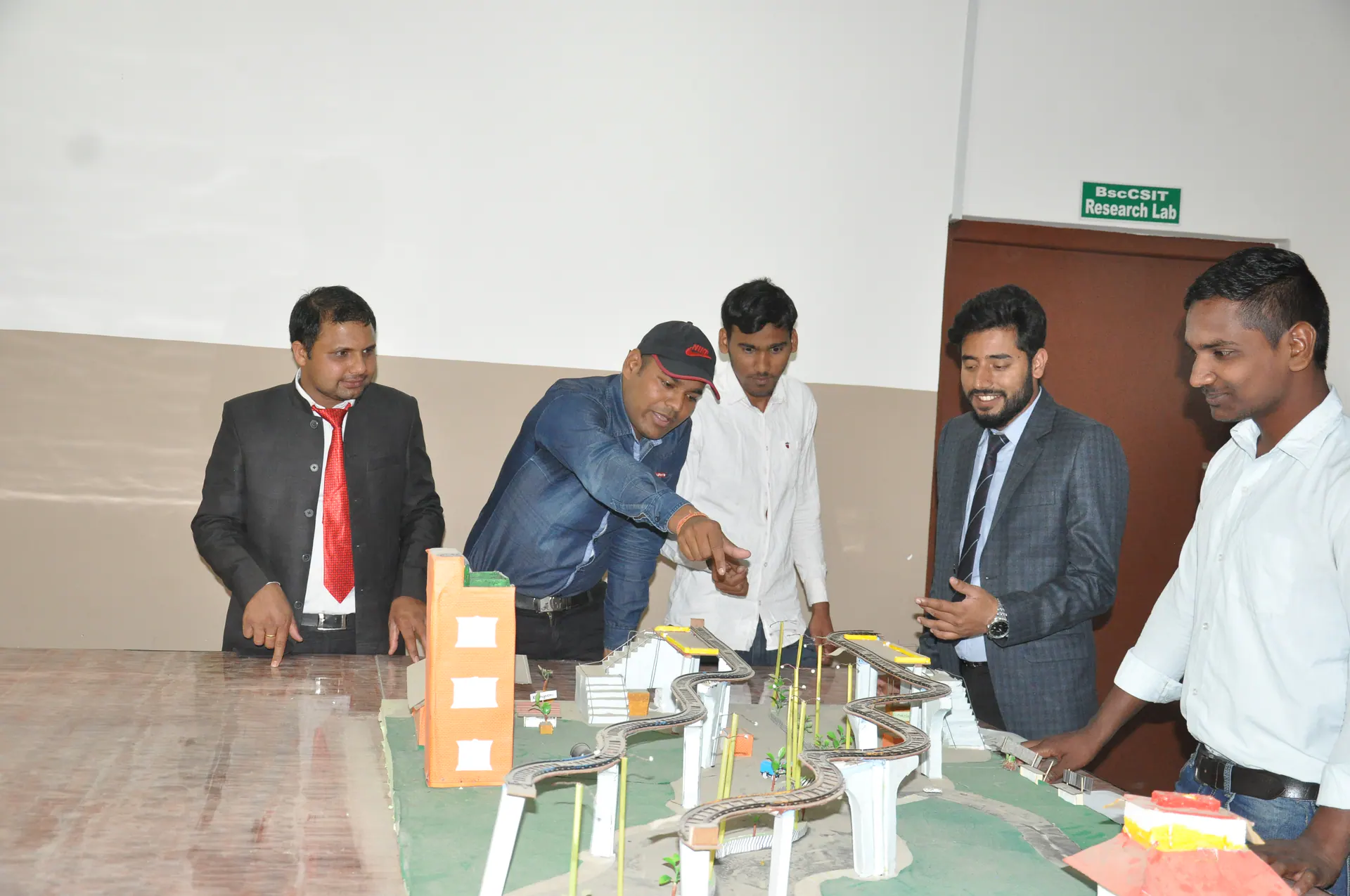 ICE staff and students discussing an engineering model during class
