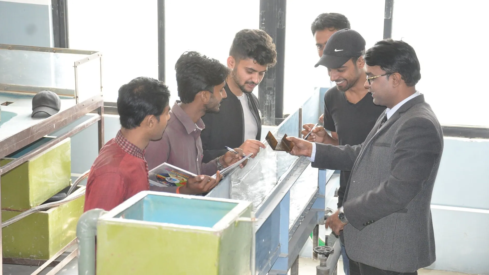 A class gathered along the open channel flume while the instructor talks them through the reading