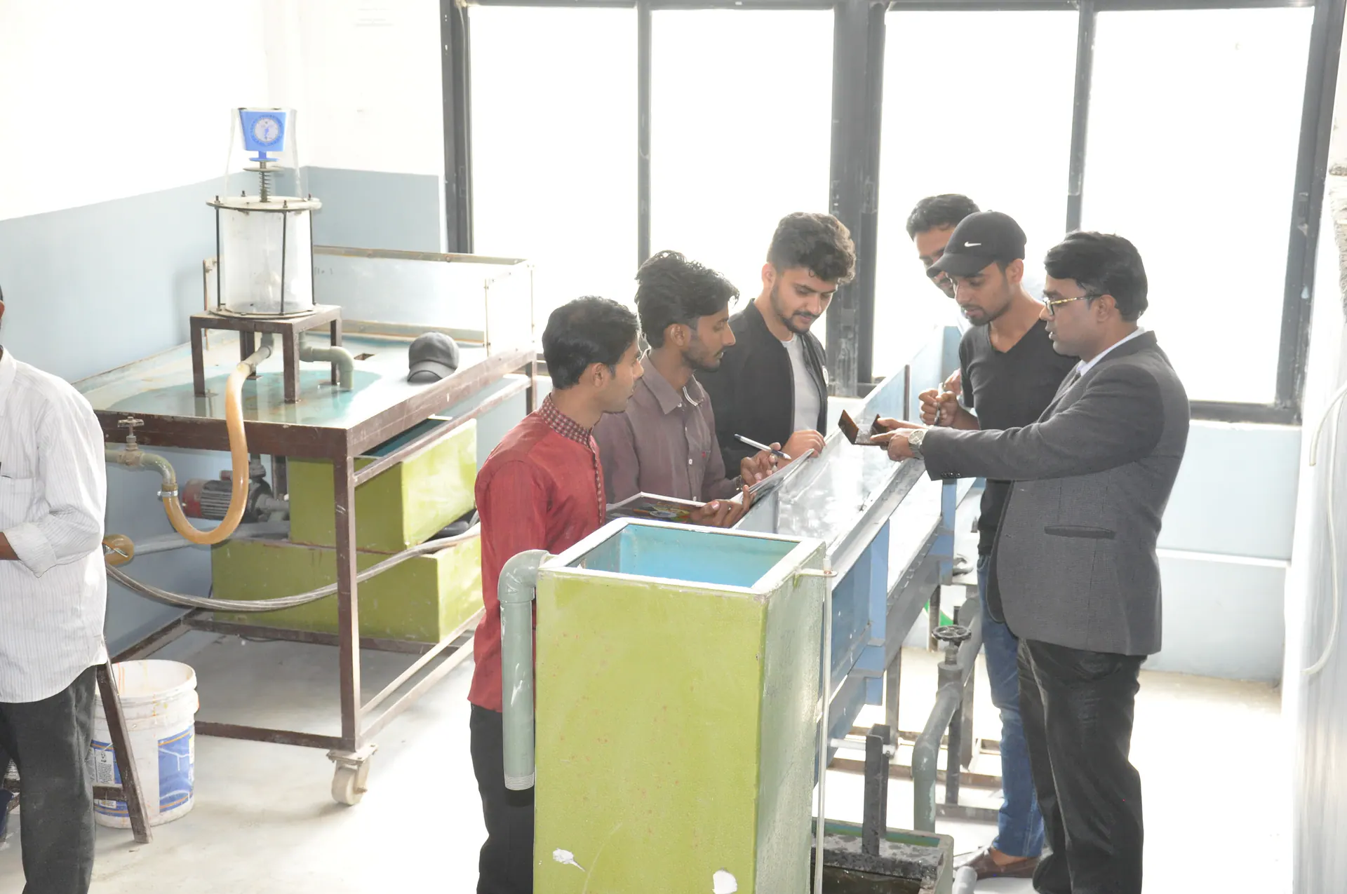 An instructor talking a group of students through a reading at the laboratory apparatus