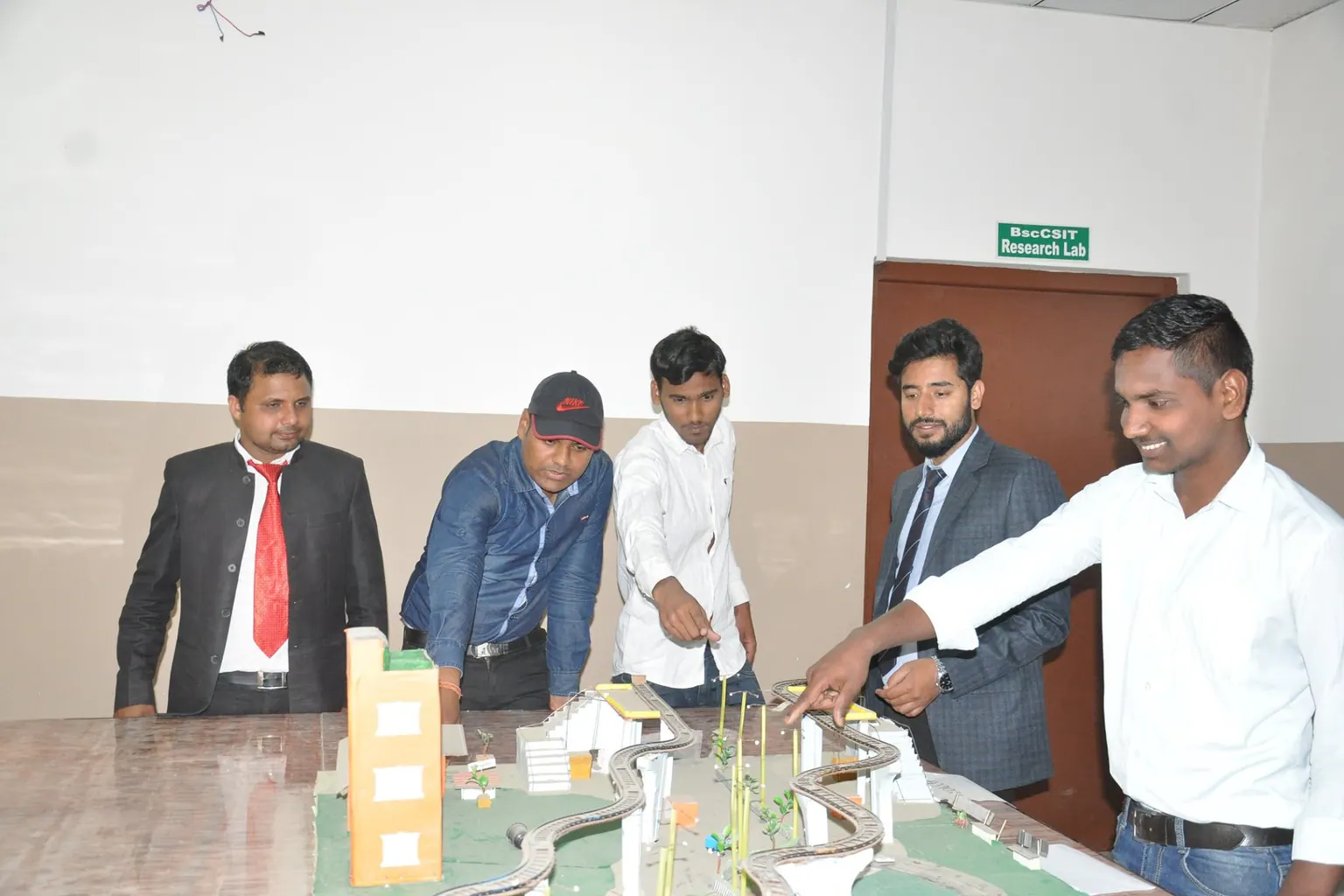 Students walking staff through a road and bridge model laid out on the review table