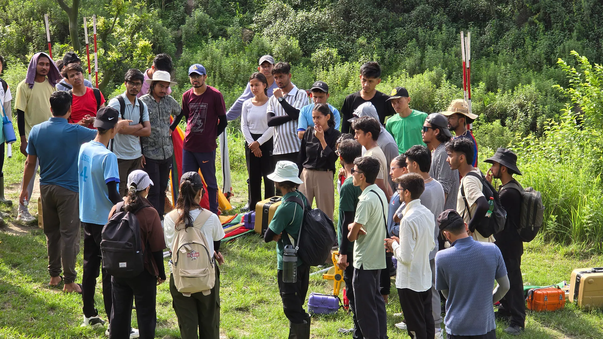 ICE students receiving a field survey briefing with surveying equipment