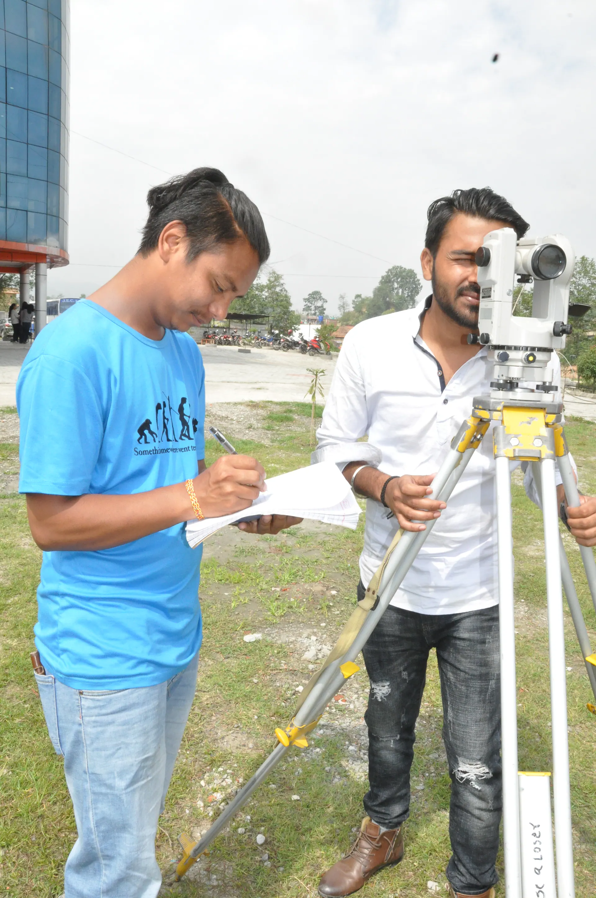 Civil engineering students checking a survey instrument and field notes
