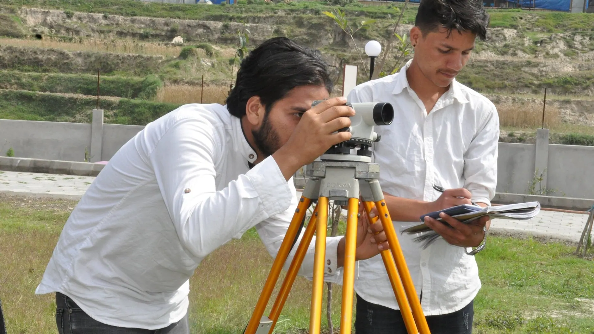 Students checking a survey instrument before taking measurements