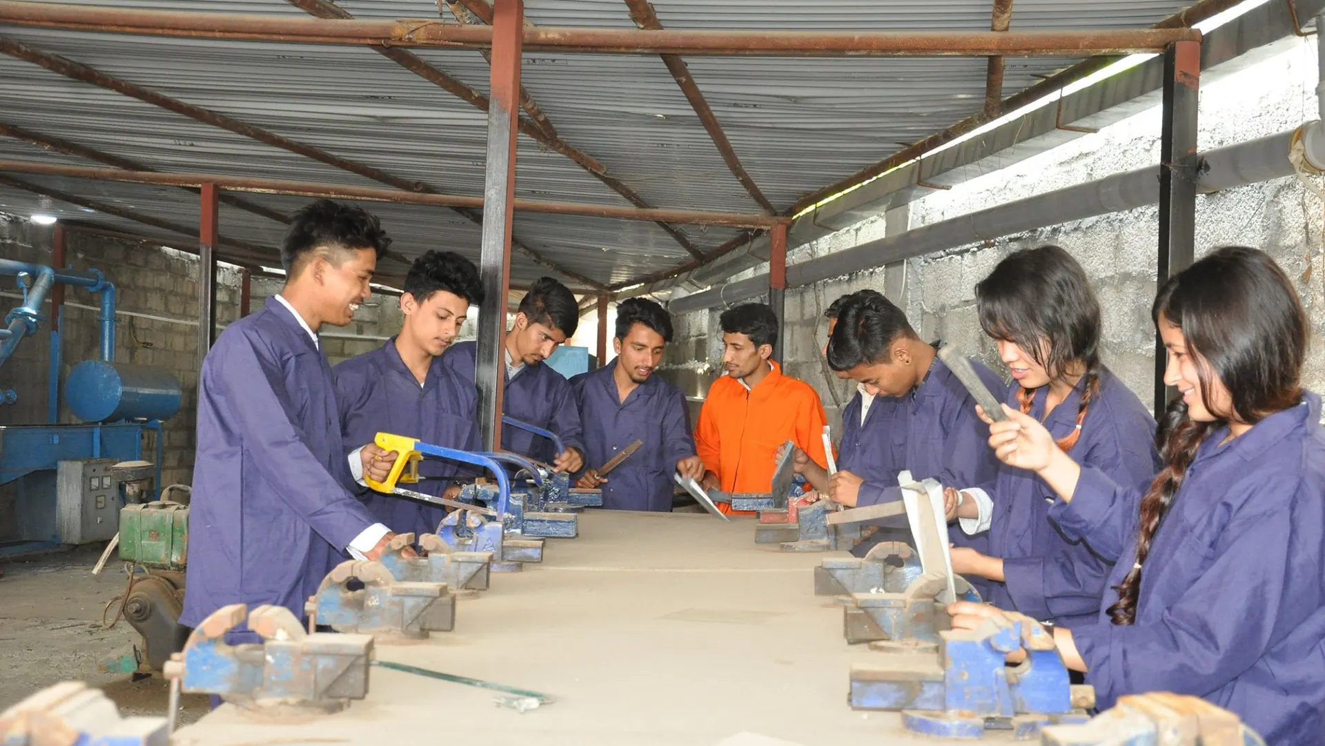 Students cutting and filing metal at the workshop vices